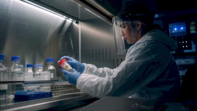 Lab technician in PPE working with biohazard sample
